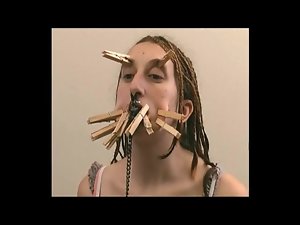 Both girl with clothes pins on her face