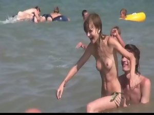 Long haired wench lays around naked at the beach